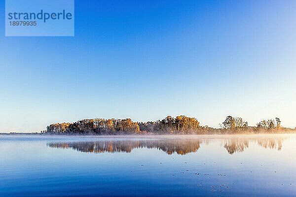Landschaftlicher Blick auf einen ruhigen See mit Wasserspiegelungen im Herbst  Schweden  Europa