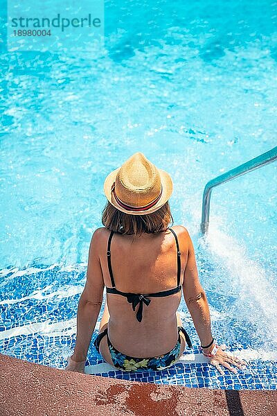 Junge Frau entspannt sich im Pool im Spa Resort im Urlaub. Sommer entspannende Konzept