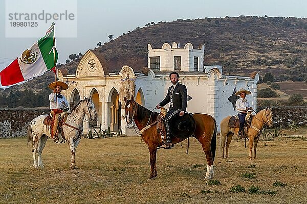 Ein stattlicher mexikanischer Charro posiert vor einer Hazienda in der mexikanischen Landschaft