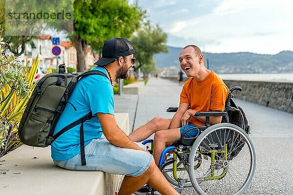 Behinderte Person im Rollstuhl mit Freunden im Sommerurlaub  die Spaß haben