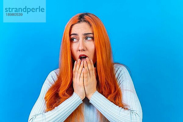 Rothaarige Frau im Studio Fotografie macht die Geste bitte auf einem blauen Hintergrund