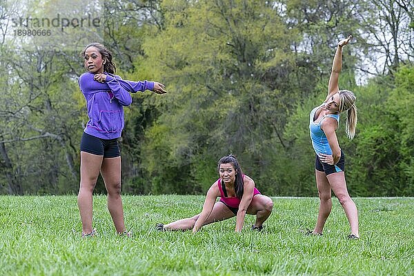 Drei junge Frauen  die einen Tag im Park genießen und sich auf ihr Training vorbereiten