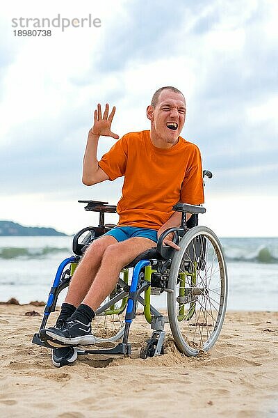 Eine behinderte Person im Rollstuhl am Strand im Sommer