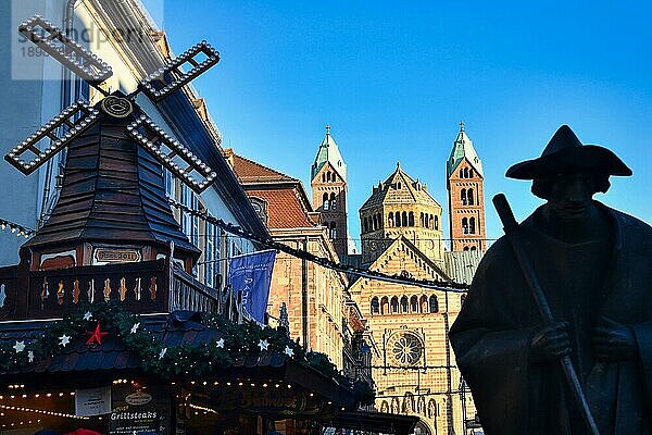 Silhouette der Pilgerstatue Jakobspilger  mit Weihnachtsmarktstand und Speyerer Dom im Hintergrund  Speyer  Deutschland  Europa