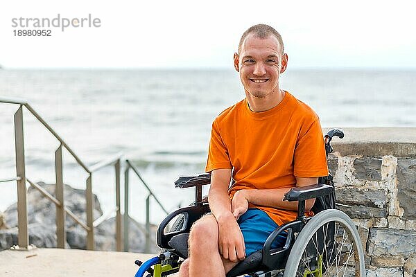 Porträt einer behinderten Person in einem Rollstuhl am Strand im Sommerurlaub