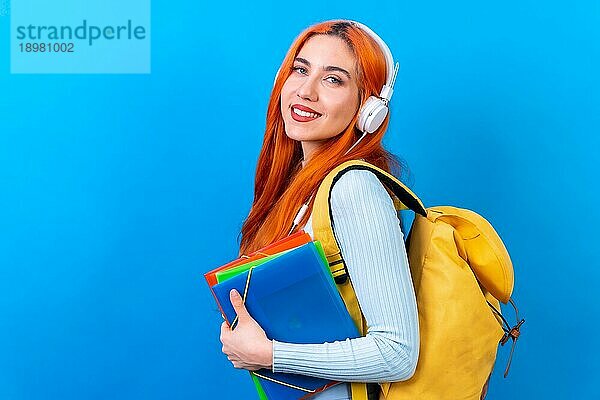 Rothaarige Frau im Studio Fotografie tanzen Collegestudent auf einem blauen Hintergrund  zurück in die Schule