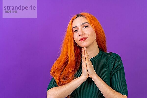 Rothaarige Frau im Studio Fotografie macht die Geste bitte auf einem lila Hintergrund