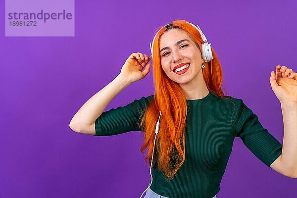 Rothaarige Frau im Studio Fotografie lächelnd tanzen auf einem lila Hintergrund