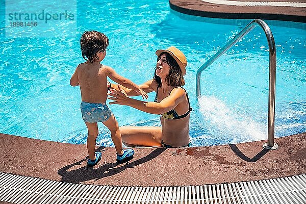Mutter und Sohn im Pool in den Sommerferien  die mit ihrer Mutter Spaß haben