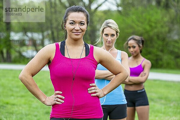 Drei junge Frauen  die einen Tag im Park genießen und sich auf ihr Training vorbereiten