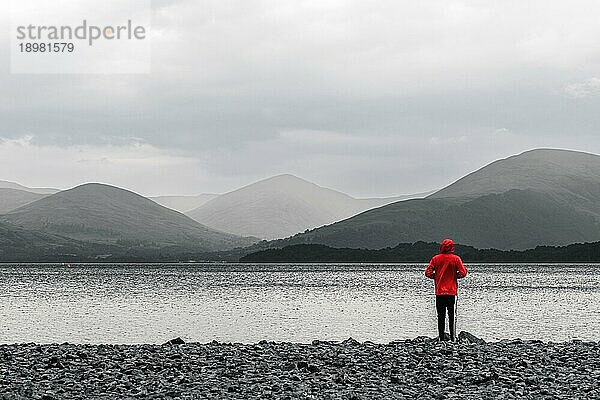 Blick auf Mointains na Boy in einer roten Jacke am Loch Lamond in schwarzweiß Nordschottland  UK