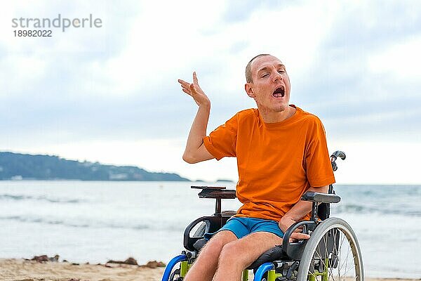 Eine behinderte Person im Rollstuhl am Strand im Sommer