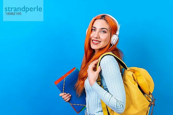 Rothaarige Frau im Studio Fotografie tanzen Collegestudent auf einem blauen Hintergrund  zurück in die Schule