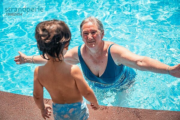 Mutter und Großmutter haben Spaß mit Enkel im Schwimmbad im Sommerurlaub  genießen das Wasser