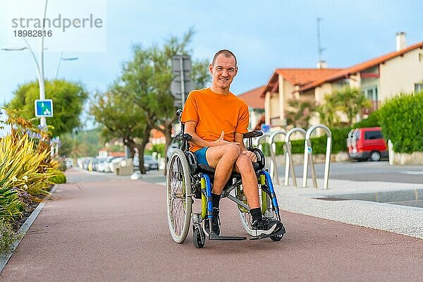 Porträt einer sehr fröhlichen behinderten Person in einem Rollstuhl im Urlaub in der Stadt