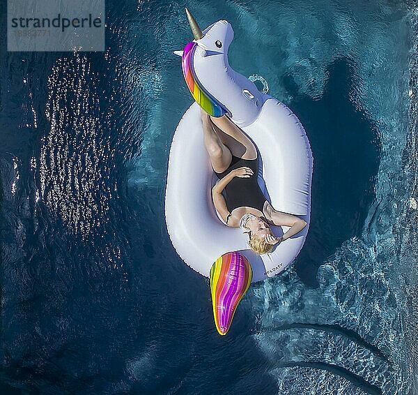 Ein blondes Model entspannt sich im Pool