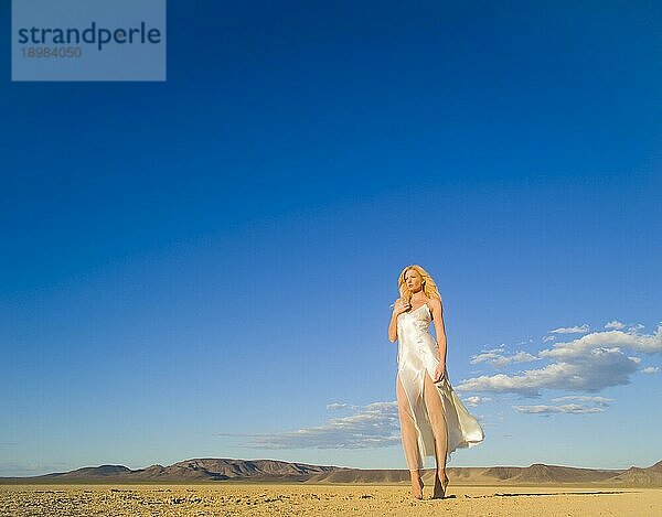 Ein blondes Modell posiert in einer Wüstenumgebung