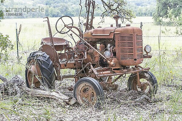 Brünettes Modell mit einem alten Traktor