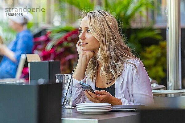 Ein schönes blondes Model genießt eine Mahlzeit im Freien