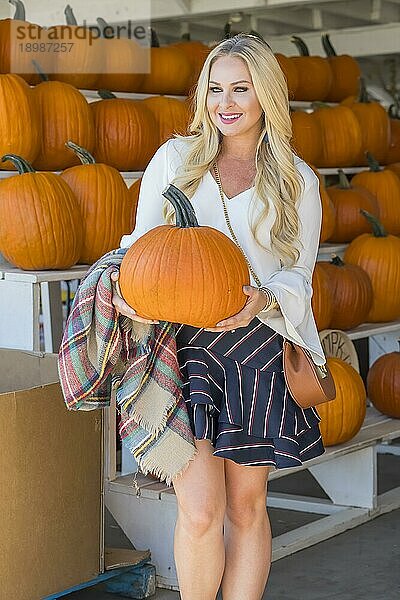 Ein blondes Model kauft Kürbisse für Halloween ein