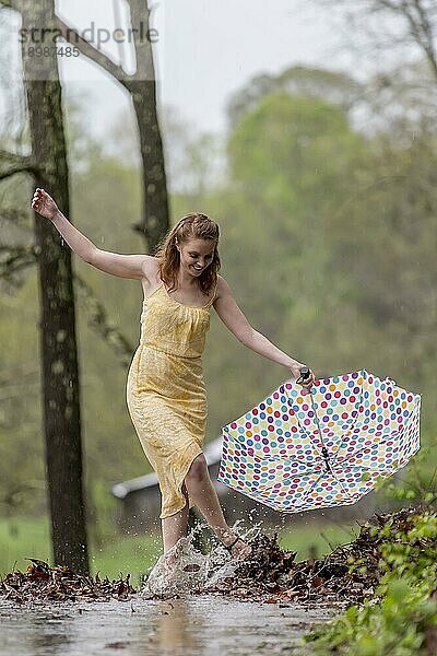 Ein rothaariges Modell posiert im Regen in einer Außenumgebung