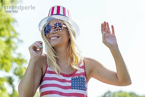 Ein patriotisches blondes Modell  das während des 4. Juli Spaß hat
