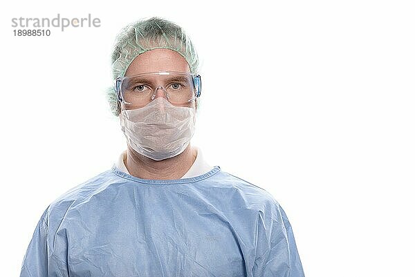 Krankenpfleger oder Arzt mittleren Alters in OP Kleidung mit OP Kittel  Maske  Schutzbrille und Kappe  der direkt in die Kamera schaut  Kopf und Schultern vor weißem Hintergrund