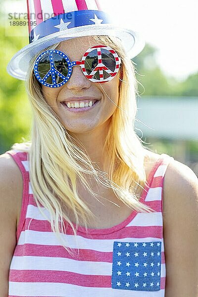 Ein patriotisches blondes Modell  das während des 4. Juli Spaß hat
