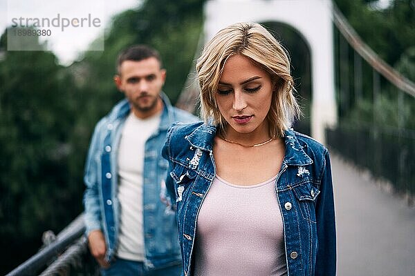 Schöne modische Paar posiert auf Fluss Brücke tragen Denim Jeans. Mode Menschen  Liebe  Emotionen und Beziehung Konzept