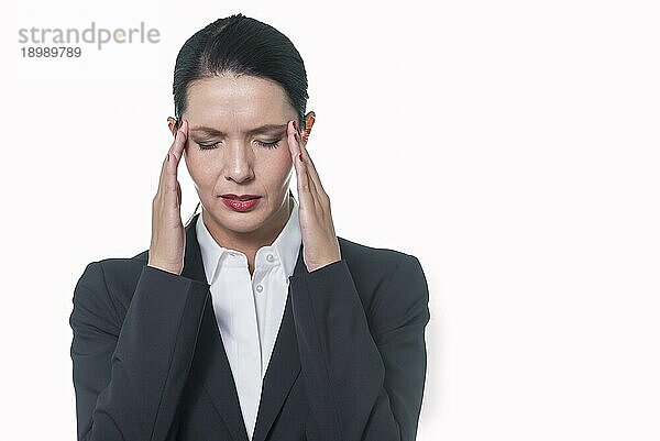 Stilvolle hübsche Geschäftsfrau mit der Hand an ihrem Kopf  die Kopfschmerzen  Stress oder Migräne anzeigt  vor weißem Hintergrund