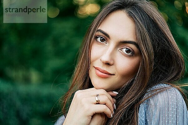 Junge schöne Frau im Freien auf grünem Hintergrund Sommer Natur. Nahaufnahme Porträt