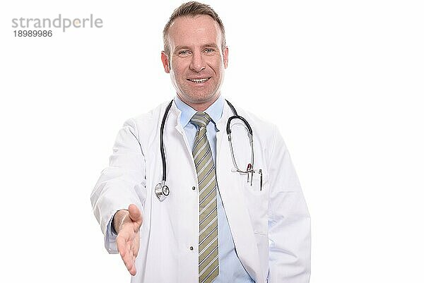 Lächelnder freundlicher Arzt mittleren Alters  der seine Hand zur Begrüßung eines Patienten ausstreckt  vor weißem Hintergrund