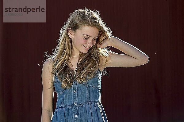Ein schönes junges blondes Mädchen im Teenageralter genießt einen schönen Tag