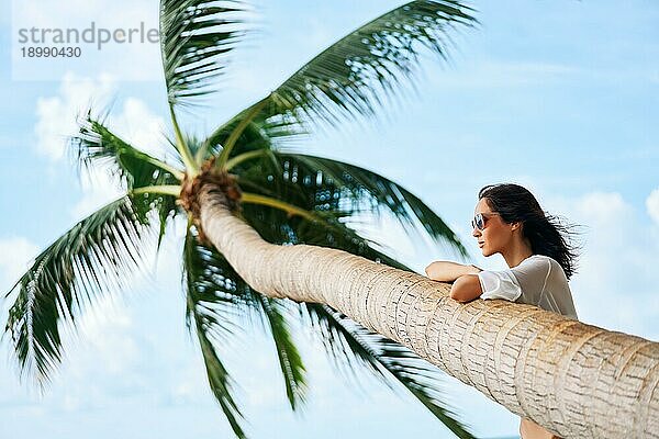 Träumende schöne Frau entspannen am tropischen Strand mit Palme. Sorglos Konzept