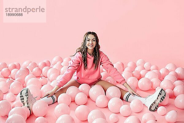 Junge trendige Frau posiert mit rosa Luftballons auf rosa Hintergrund. Pop Art. Celebraion  festlich  Spaß Konzept