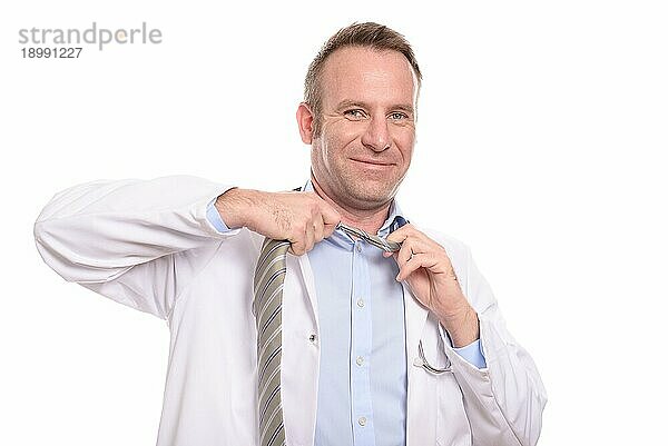 Lächelnder Arzt  der am Ende seiner Schicht seine Krawatte lockert  zufrieden mit dem Verlauf seines Tages  vor weißem Hintergrund