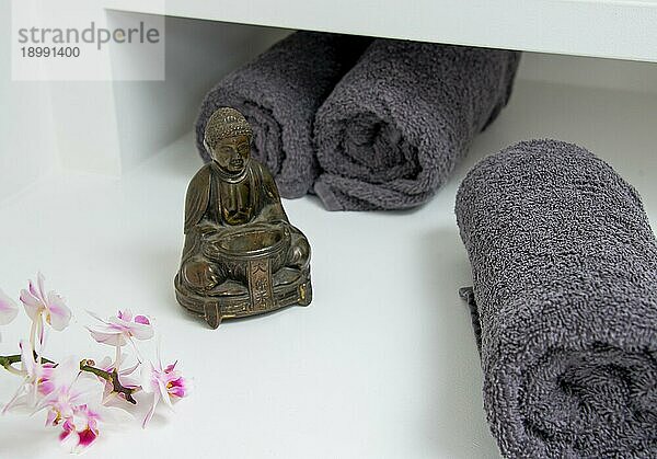 Ein Stillleben mit Buddhafigur Orchideenblüte und Handtuch