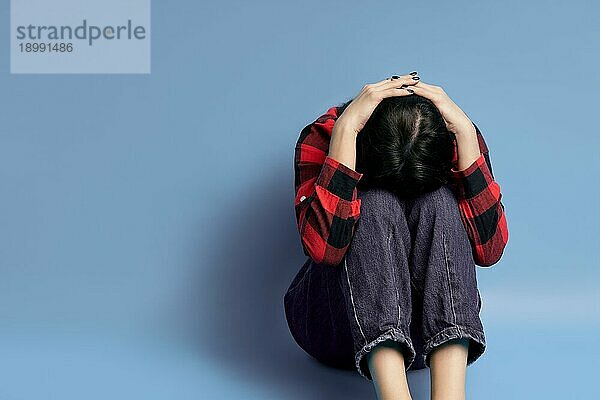 Depressive junge Frau sitzt allein auf dem Boden mit Kopie Raum. Dramatisch  einsam  traurig  Emotionen Emotionen Konzept