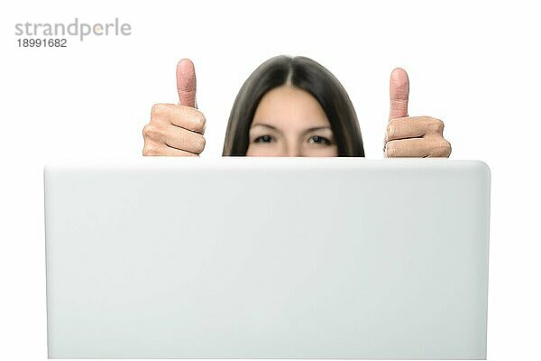 Attraktive Frau zeigt Daumen hoch Zeichen auf beiden Händen vor einem Computergerät. vor weißem Hintergrund