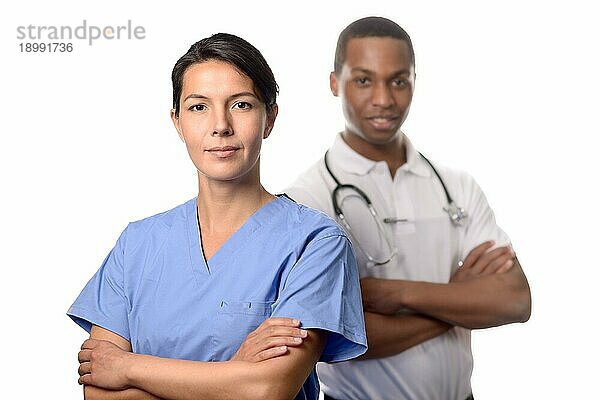 Erfolgreiche attraktive Ärztin oder Chirurgin in Kitteln  die mit verschränkten Armen vor einem afrikanischen männlichen Arzt oder Berater eines medizinischen Expertenteams steht  auf weißem Hintergrund