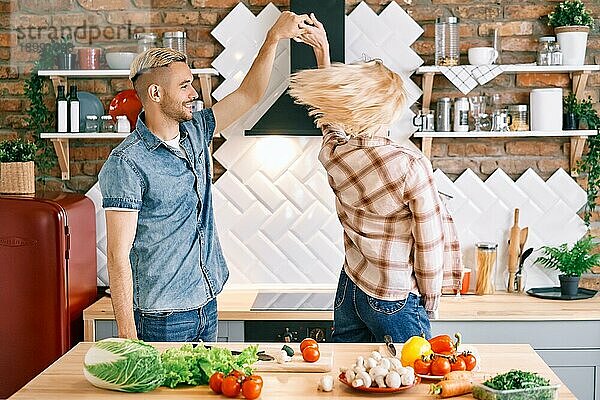 Glückliches junges Paar in der Liebe tanzen in der Küche zu Hause und Spaß haben. Beziehung  Feier  Dating Konzept
