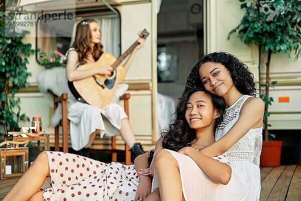 Junge glückliche Frauen entspannen und haben Spaß während der Sommerferien. Asiatische und afroamerikanische Frau umarmt. Frauen Freundschaft Konzept
