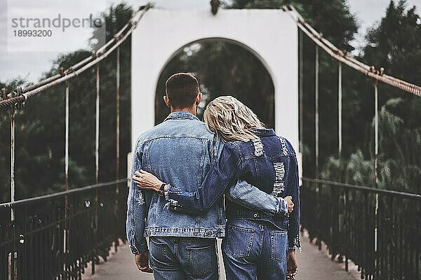 Rückansicht des umarmenden Paares  das auf der Brücke bleibt und die Ruhe genießt. Instagram Filter Effekt