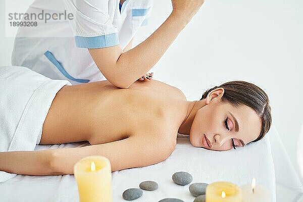 Junge Frau erhält eine entspannende Rückenmassage von einem professionellen Therapeuten in einem Spa Salon. Körperpflege  Ruhe Konzept