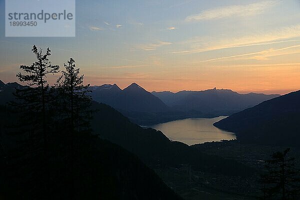 Sonnenuntergangsszene in den Schweizer Alpen. Umrisse von Niesen  Stockhorn und anderen Bergen. Thunersee