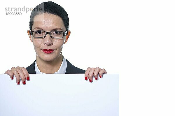 selbstbewusste schöne Geschäftsfrau mit Brille  die ein leeres weißes Schild mit Platz für Ihren Text oder Ihre Werbung hält