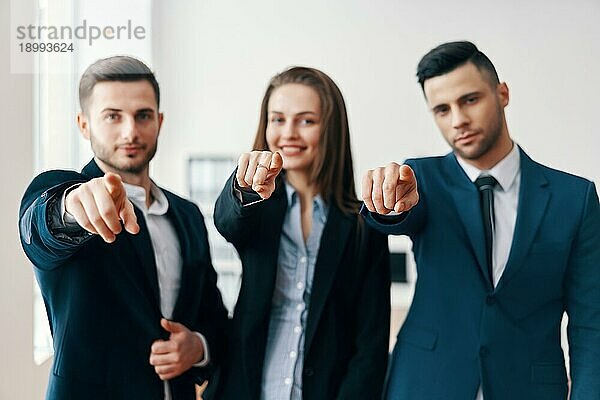 Junge fröhliche Geschäftsleute zeigt mit dem Finger auf Sie. Wahl und Geste Konzept