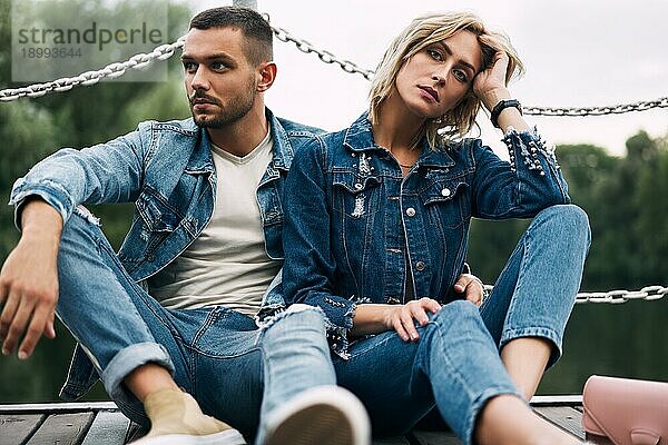 Schöne modische Paar posiert auf Fluss Brücke tragen Denim Jeans. Mode Menschen  Liebe  Emotionen und Beziehung Konzept