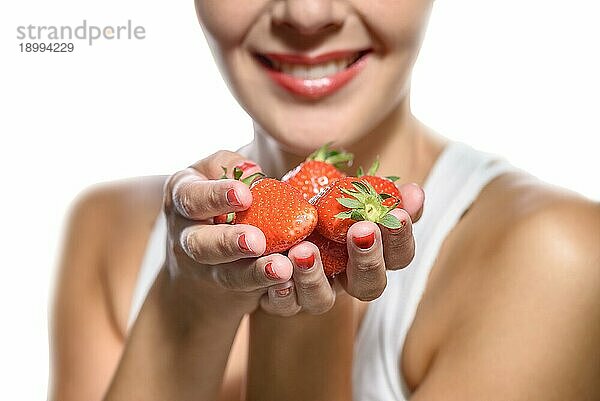 Lächelnde Frau mit Erdbeeren in der Hand auf weißem Hintergrund