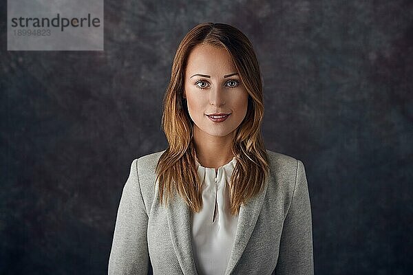 Porträt einer eleganten Frau vor dunklem Hintergrund